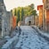 A narrow cobblestone road with ancient buildings on both sides.